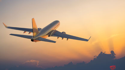 Avión de pasajeros volando sobre las nubes durante el atardecer.